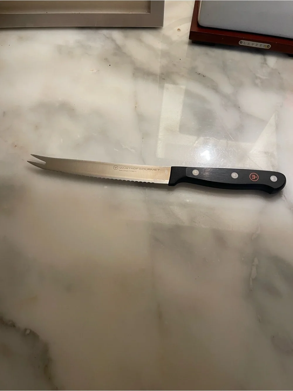Wusthof Serrated Kitchen Knife with Black Handle and Silver Blade.
